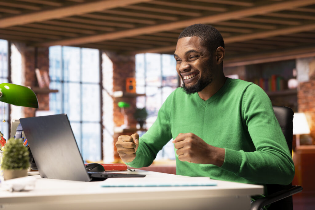 joyful man at home happily shaking fists, ecstatic